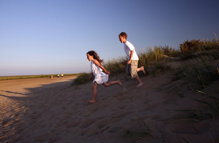 children running in the sand dunes