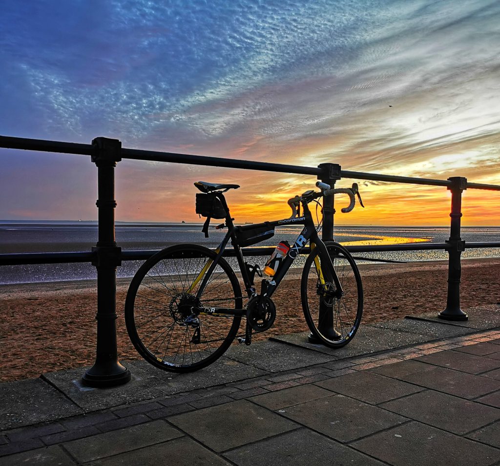 image of bike against railings at Cleethorpes beach at sunset